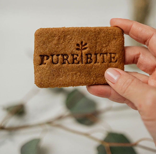 Pink table setting with red velvet pancakes, rolled strawberry cake, fresh berries, glasses, and spring flowers